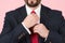 Close-up of hands adjusting red tie on white shirt. Businessman in black suit ties a red tie. Close up of hands