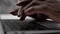Close up hands African American man doctor typing on keyboard laptop in clinic