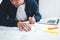 Close-up of hands architect uses laptop and building blueprint on working table in office space