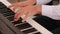 Close up of hands as young man sits at grand piano and plays at home