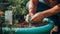 A close-up of hands assembling a rainwater harvesting system, utilizing sustainable practices to reduce ozone impact