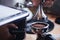 Close-up of hands barista presses ground coffee using a tamper. The process of making coffee step by step