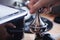 Close-up of hands barista presses ground coffee using a tamper. The process of making coffee step by step. Concept of beverages