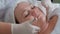 Close-up of hands of the beautician in white gloves during the procedure in the cosmetology center. Facial massage of a fat girl i