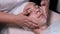 Close-up of the hands of a beautician who lathers the face of a boy. Male client gets facial cosmetology procedure in beauty salon