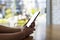 Close up hands of beautiful young woman holding mobile, smart phone sitting in cafe. Soft focus hands of women holding and use