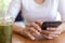 Close up hands of beautiful young woman holding mobile, smart phone sitting in cafe. Soft focus hands of women holding and use