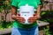 Close up of hands of black African Australian woman holding a kitchen compost container in garden