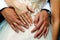 Close-up hands of bride and groom with wedding rings, newlyweds embracing. Concept of love, wedding and family