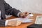 Close up hands of business woman wearing gray striped suit, holding expensive pen and paper documents.