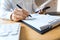 Close-up of hands Businessman reading and writing with pen signing contract over document for Completing Application Form at work