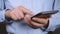 Close-up of hands of businessman using smartphone.