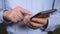 Close-up of hands of businessman using smartphone.