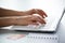 Close-up of hands of businesswoman typing on a laptop.