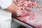 Close-up of the hands of a butcher slicing steaks