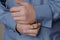 Close-up of hands buttoning a cufflink on the sleeve of a blue s