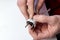 Close-up on the hands of a Caucasian electrician holding a screwdriver, working on the plug of an electrician on a white