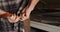 Close up of hands of caucasian male knife maker in workshop tying apron