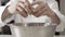 close-up of hands of a chef breaking eggs. ingredients to prepare cake. man with white chef uniform making a pie in his