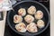 Close-up of the hands of a chef in a professional kitchen cooking rose flower shape dumpling, chinese food