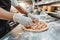 Close up of the hands of the chef who is preparing a pizza