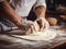 close-up of the hands of a chef who is rolling out the dough with a rolling pin