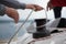 Close up of hands coiling up a rope, the halyard around the winch on a sailboat