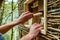Close-up of hands constructing a tiny home from sustainable materials.