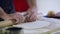 Close-up of hands of a cook and dough. Ingredients on the table.