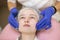 Close up of hands of cosmetologist in blue rubber gloves, appliying professional peeling or cleansing foam to young teen