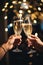 close up on hands of a couple holding glasses of champagne making a toast. celebration with champagne with blurred background boke