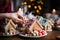 Close-up hands craftily decorate a gingerbread house for the holiday season