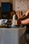 Close-up of the hands of the craftsman while creating a ceramic pot on the lathe