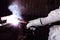 Close up hands of craftsman welder with torch and protective gloves welding metal steel with spark in the factory. Manufacturing i