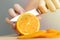 Close up hands cutting a ripe juicy orange with a knife. Healthy fruit food preparation concept