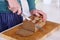 Close up of hands cutting a slice of bread