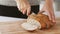 Close up of hands cutting white bread with knife