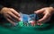 Close-up of the hands of a dealer or croupier shuffling poker cards in a smoky club against a green table with chips. Concept of