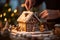 Close-up hands decorating a gingerbread house