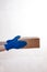 Close up hands delivery man medical gloves hold empty cardboard box on white background.