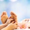 Close up of hands doing reflexology treatment on feet in spa.