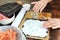 Close up - hands of elderly caucasian woman adding rice vinegar to rice for making sushi at home.