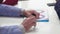 Close up of hands of elderly man lying on white table