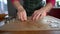 Close up hands of female baker makes cookies from dough using a metal mold. The dough lies on greaseproof paper