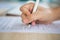 Close up of hands filling out employment application form with a pen.