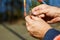 Close-up of the hands of the fisherman. Fisherman holding a fishing pole, bobber and hook