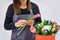 Close-up hands of florist with flowers. Florist holding blooming bouquet of pink tulips on a linen background. Flowershop concept.