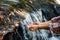 Close up hands of girl drinking water from waterfall