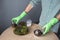 Close-up of hands in gloves pour peat into the florarium