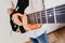 Close-up of the hands of a guitarist performing a song while pressing the strings